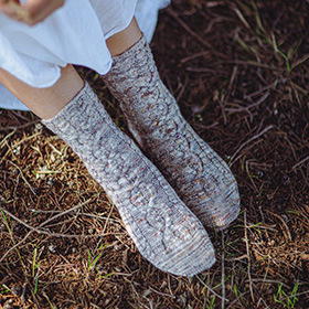 A model wearing knit grey socks in the grass