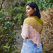 A model wearing a pink and yellow knit shawl