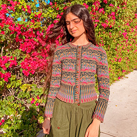 A model wearing a striped knit cardigan with flowers in the background