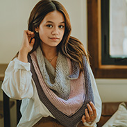 A model wearing a colorful knit shawl