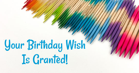 Your Birthday Wish Is Granted! text next to a rainbow gradient of double point knitting needles