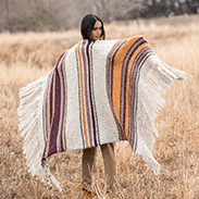 A model wearing a white and brown striped throw
