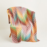 A colorful knit blanket draped over a chair