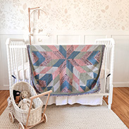A baby quilt draped over a crib