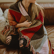 A modeal wearing a knit colorful shawl