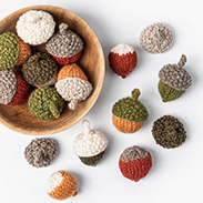 Mini knit acorns in a bowl and on a table