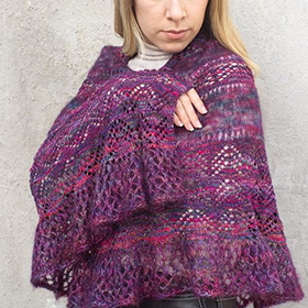 A model wearing a purple and pink striped shawl