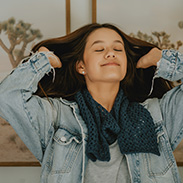 A model wearing a blue knit scarf