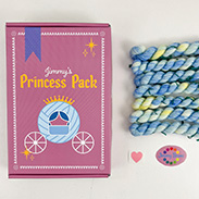 A pink box that says Jimmy's Princess Pack with an illustrated carriage and mini skeins of blue variegated yarn