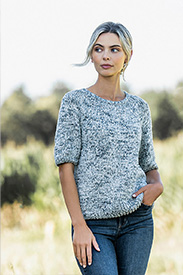 A model wearing a blue knit sweater and blue jeans