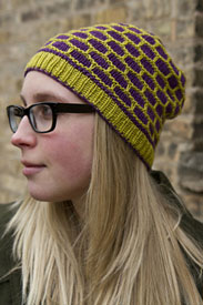 A model wearing a green and purple knit hat