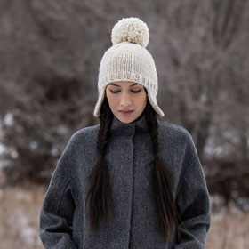 A model wearing a white knit hat
